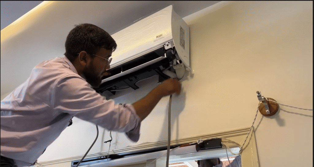 Technician inspecting ceiling cassette air conditioner.