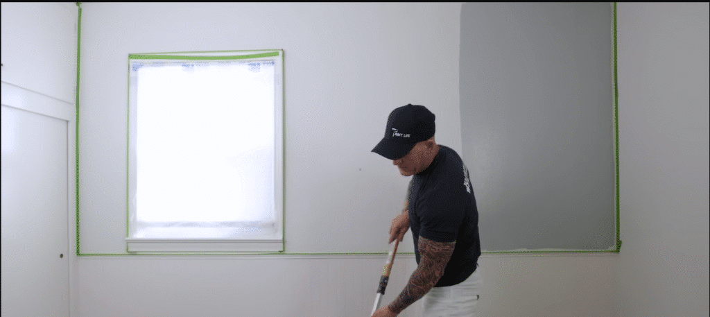 Painter applying waterproof paint on a building façade.