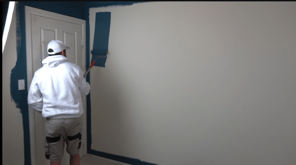 Professional painters coating office walls in neutral colors.