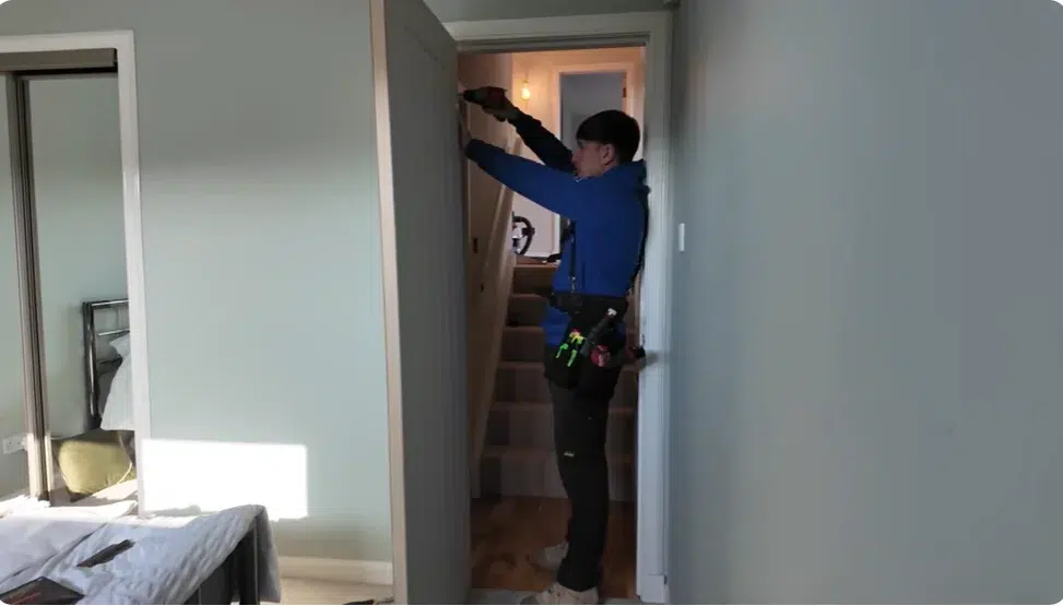 Royalsons carpenter fitting a modern wooden door in a Dubai home