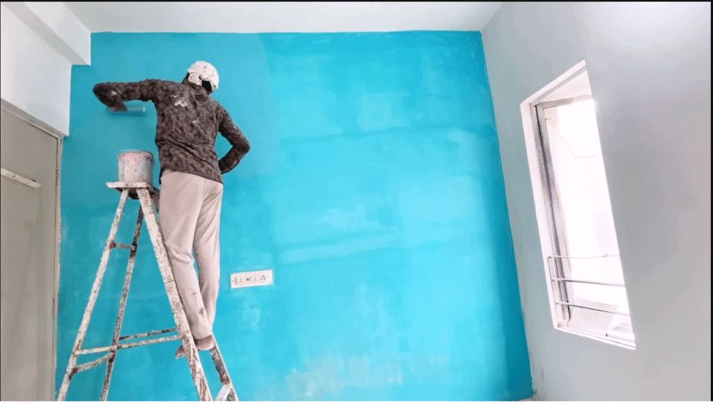 Artist applying textured paint to a feature wall.